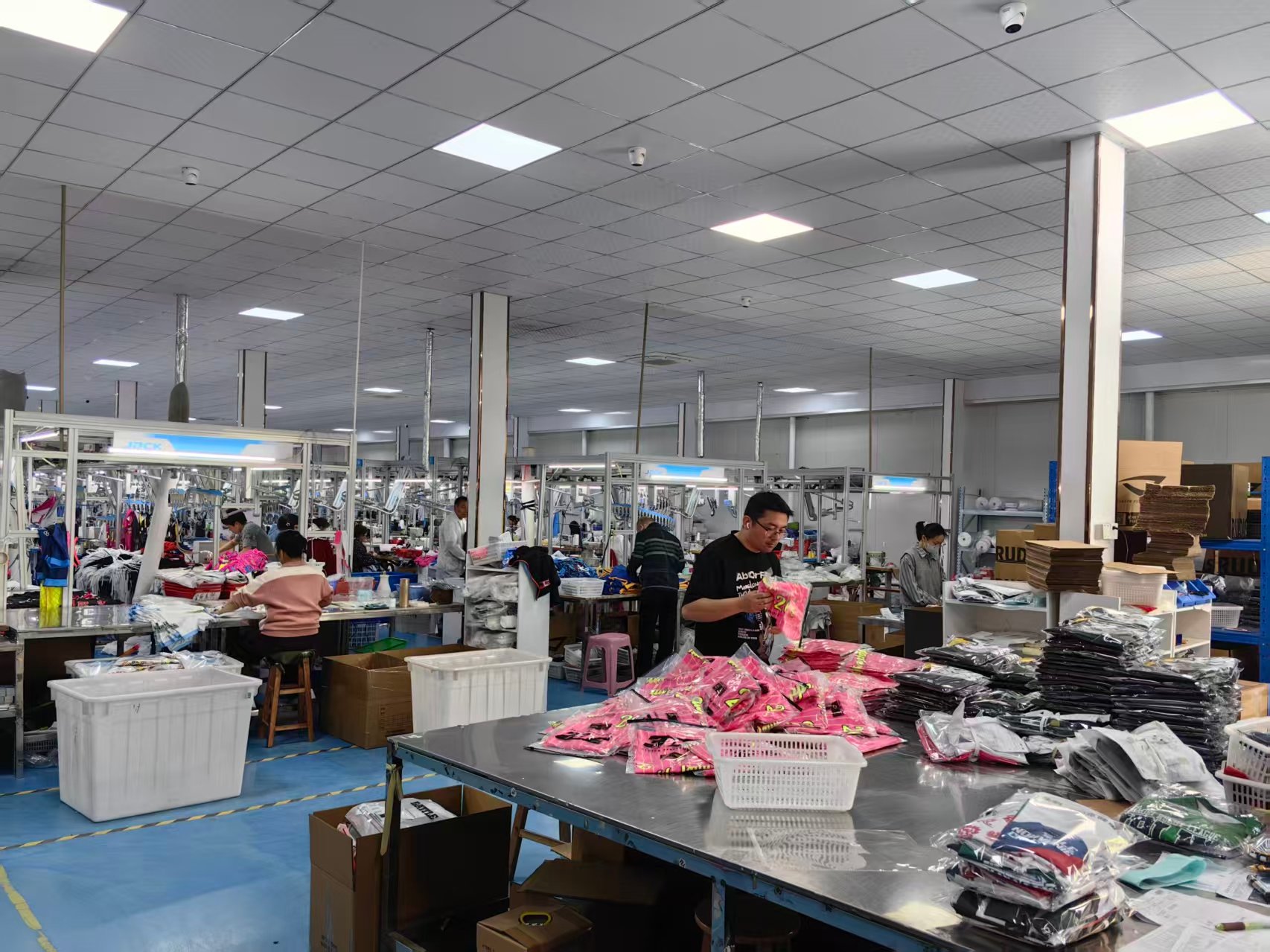 AQL 2.5 检验台与成品经期内裤，汕头生产站点：员工在不锈钢检验台前逐件核对粉色独立包装成品