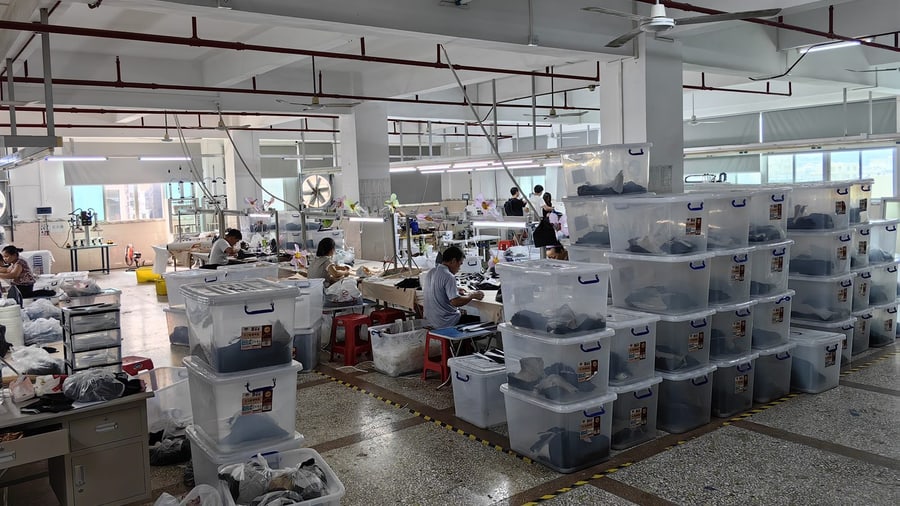 LJVOGUES 汕头生产基地车间内的待流转物料周转箱:经期裤半成品按工序分箱摆放